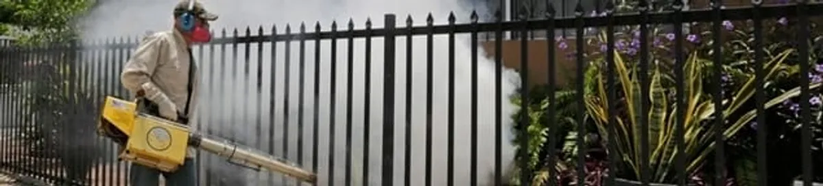 Mosquito control technician fogging a yard perimeter for mosquito reduction in Baton Rouge, LA
